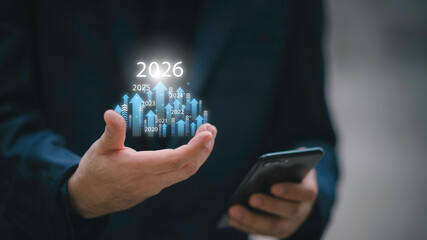 Businessman drawing digital growth arrows and bar graph with 2026 target. Futuristic concept for business goals, technology strategy, data-driven planning, success and innovation.