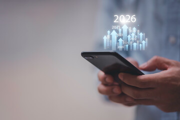 Businessman drawing digital growth arrows and bar graph with 2026 target. Futuristic concept for business goals, technology strategy, data-driven planning, success and innovation.