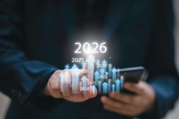 Businessman drawing digital growth arrows and bar graph with 2026 target. Futuristic concept for business goals, technology strategy, data-driven planning, success and innovation.