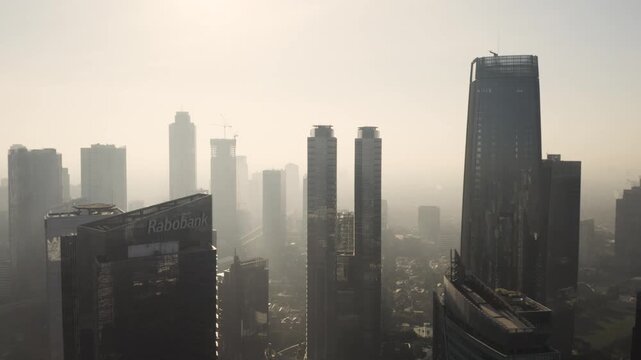 Jakarta Skyline in Haze: Aerial View of Modern Business District and Skyscrapers in Golden Morning Light