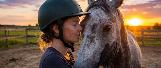 Young rider enjoys sunset with horse in peaceful field