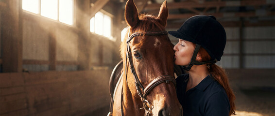 Horse and rider share a moment in indoor arena