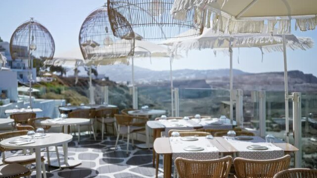Santorini terrace cafe scene with shallow bokeh, soft defocused tables and umbrellas overlooking cliffs and sea, outdoor; background backdrop copyspace calm.