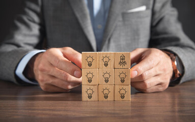 Idea creation and innovative product launching concept. Wooden block with rocket and idea generation icons. Idea creation, innovation and the launch of a new product from concept to execution.