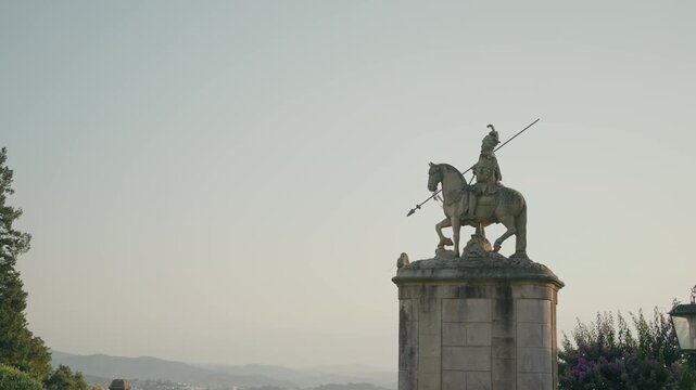 historic equestrian statue framed by soft evening light in braga