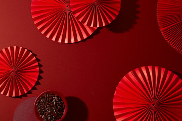 Flat lay view with red paper fans and snack decorations. Strong visual rhythm for holiday web design, social posts and advertising templates. Blank space, Lunar new year concept