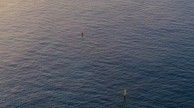 Minimalist Sea with Two Yellow Buoys, Golden Hour Aerial Orbit View