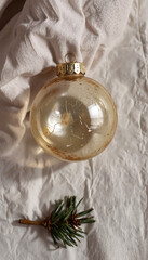 Vintage glass Christmas ornament on textured fabric with pine branch  