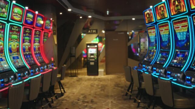 Casino interior with rows of slot machines and neon signs, softly blurred and defocused for bokeh background interior; background backplate copyspace template.
