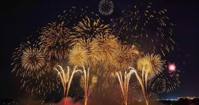 Brilliant red and gold fireworks paint sweeping arcs across a starry sky, recorded in long-exposure photography for smooth motion, crisp lighting, and natural smoke diffusion.