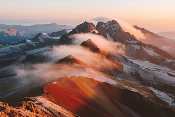 Sunrise over snow-capped mountains with mist swirling through valleys and colorful rock formations