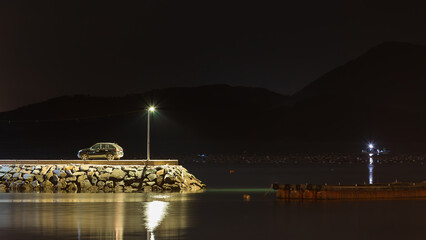 Quiet Night at the Breakwater End with a Lone Streetlight and Parked Car