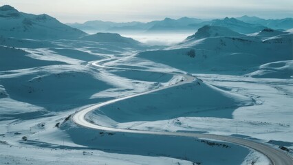 Snow-covered mountain landscape with winding road through winter terrain