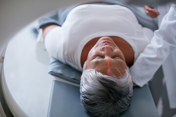 Diagnosis, healthcare and MRI with senior patient in hospital for assessment or brain anatomy. Appointment, CT scan and medical with old woman in machine at clinic for neurological exam or function