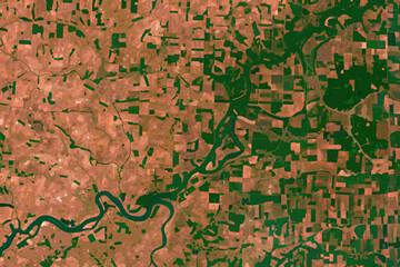 Aerial view of a river winding through agricultural land and forests