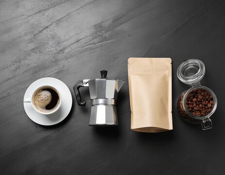 Flat lay of coffee brewing essentials: Moka pot, freshly brewed coffee cup, roasted beans in glass jar, and blank kraft paper pouch on a dark textured background with copy space. - Powered by Adobe