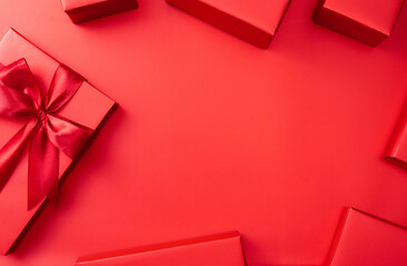 Red background with gift boxes, festive holiday theme suitable for Christmas, New Year, and Chinese New Year