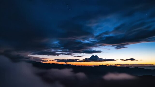 Sunset sky with vibrant orange and purple clouds over dark mountain silhouettes and mist creating dramatic peaceful nature landscape at evening horizon during twilight with cloud formations