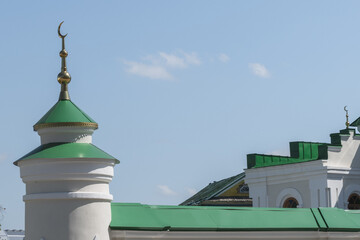 Green domes of a mosque with a golden crescent. Cultural heritage and the spiritual significance of architectural design.