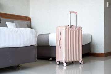 Luggage positioned next to comfortable hotel bed, highlighting travel lifestyle and room interior