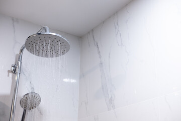Close-up of rain shower streaming water, showcasing clean modern bathroom and calming atmosphere