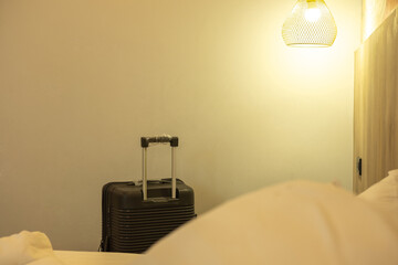 Travel-ready large suitcase placed by the bed in a neat room, showing journey and accommodation