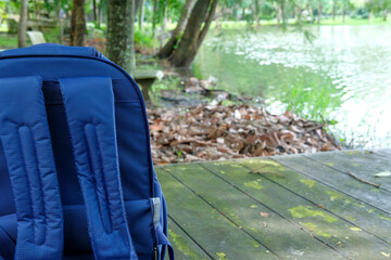 Travel backpack placed at the edge of a natural pond, capturing adventure and peaceful outdoor vibes