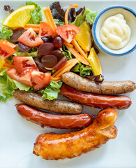 Grilled Mixed Sausages with Fresh Salad and Fruits.