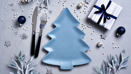 Festive christmas table setting with tree shaped plate and gift