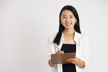 Obraz premium Smiling Woman Holding Clipboard and Pen Against White Background