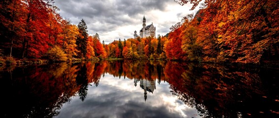 Castle by the lake surrounded by colorful trees in autumn