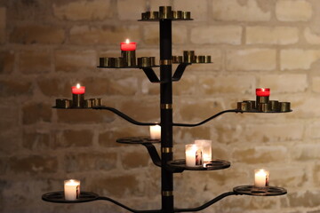 Votive candles on a metal stand in a church