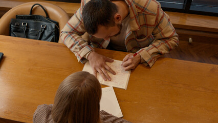 Two colleagues brainstorming ideas in a cozy coffee shop with notebooks