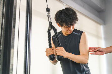 Gym, young Asian man receiving personal training at training gym