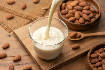 グラスに注がれるアーモンドミルクとナッツ素材
