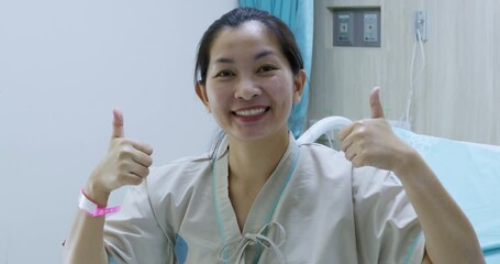 A joyful nurse shares a thumbs-up in a hospital room showcasing positivity and dedication to patient care.