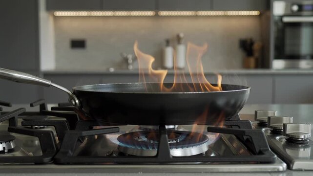 Frying pan on a gas stove with flames cooking food. Kitchen background with appliances for home cooking and gourmet meal preparation.