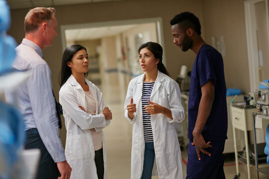 Healthcare, doctor and meeting in hospital for communication, consulting and planning. Group, discussion and medical professional with people for advice, compliance or consent for surgery in clinic