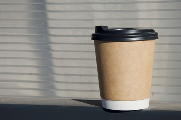 Takeaway coffee cup on outdoor surface.