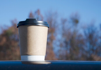 Takeaway coffee cup on outdoor surface.