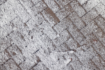 Winter texture of paving slabs covered with snow, top view, background surface in snow