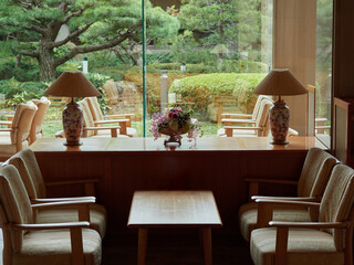 日本の観光地のホテルの和風庭園とロビーの椅子とテーブルの風景