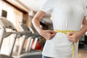 Diet and dieting. Beauty slim female body use tape measure on fitness. Woman in exercise clothes achieves weight loss goal for healthy life, crazy about thinness, thin waist, nutritionist.