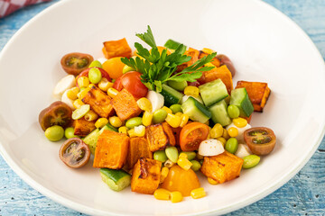 Roasted sweet potato salad mixed with corn, cucumber and herbs
