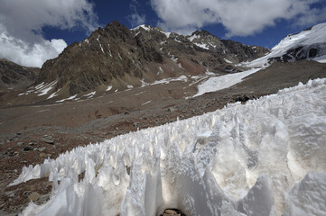 The enchanting beauty of the snowy mountains. The view of snow and rocks on the mountain tops.