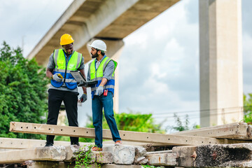 Fototapeta premium Railway engineer and technician inspecting concrete pier sections and construction debris