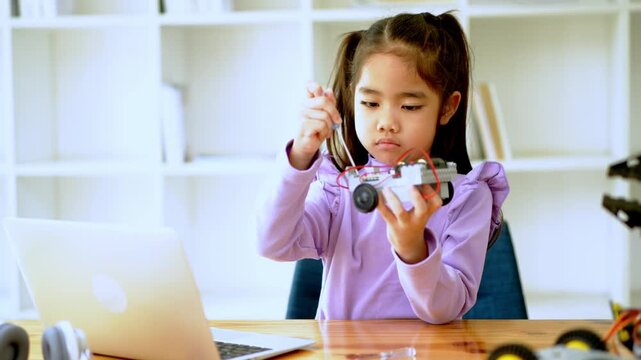 Child engaging in creative play with toy vehicle at home office desk interactive learning environment focused perspective