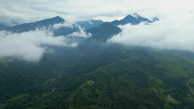 A sky-high aerial of mist-covered mountain peaks and forest ridges stretching across Quinawan in Bataan, Philippines