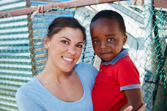 Volunteer, poverty and portrait of woman with kid outdoor for community service, ngo program and charity. Kindness, social responsibility and welfare with person and child for humanitarian outreach