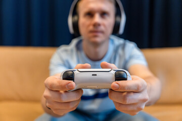 A young man is playing a game console, Focus on the gamepad